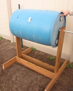 a large blue barrel sitting on top of a wooden stand