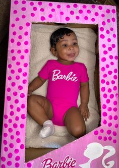 a baby doll in a pink box with polka dots on it's body and name barbie