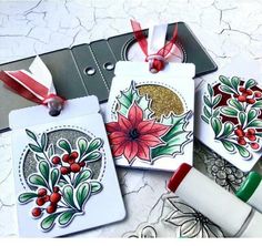 three tags with christmas designs on them and some crayon markers next to it