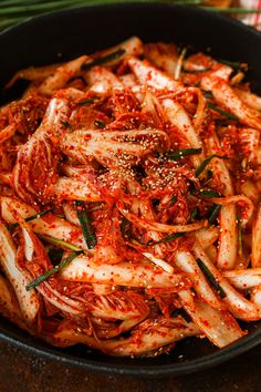 a pan filled with pasta and sauce on top of a table