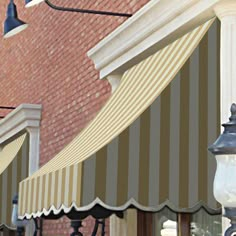 an awning on the side of a building next to a street light and lamp post