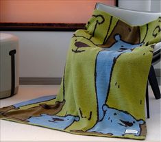 a green and blue blanket sitting on top of a chair