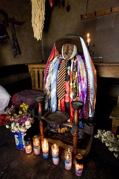 a pile of ties sitting on top of a chair next to candles