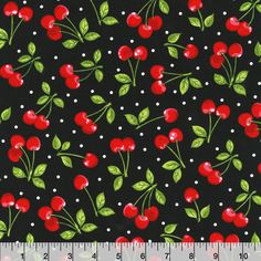 a black background with red cherries and green leaves on it, along with white polka dots