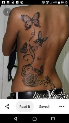 the back of a woman's body with butterflies and roses on it