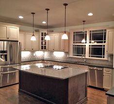 a large kitchen with stainless steel appliances and white cabinets