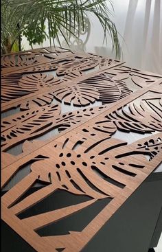 an intricately designed wooden table top in the middle of a room with a plant