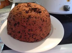 a cake sitting on top of a white plate next to an instant pot roaster