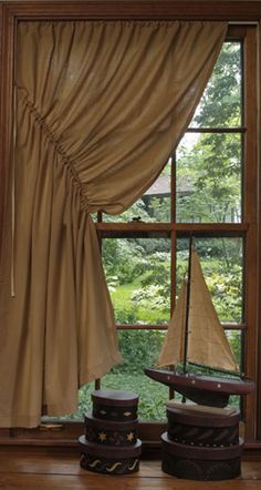 a sailboat sitting on top of a wooden table in front of a large window