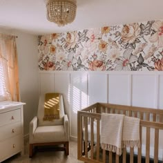 a baby's room with floral wallpaper and a crib in the corner