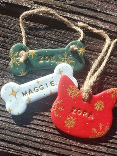 two dog bone ornaments are sitting on a wooden table