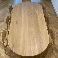 a wooden table and chairs in a room with hard wood flooring on the ground