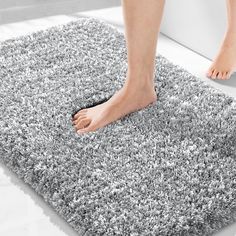 a person standing on top of a gray rug