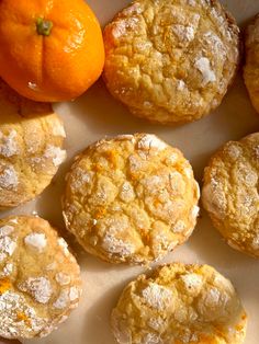 some oranges and muffins are on a plate