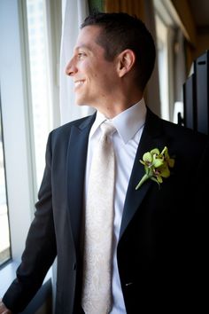 a man in a tuxedo looking out the window