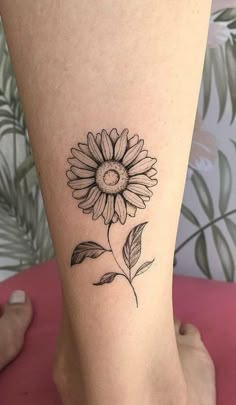 a small sunflower tattoo on the ankle