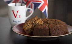 two pieces of cake on a plate next to a cup with the british flag in the background