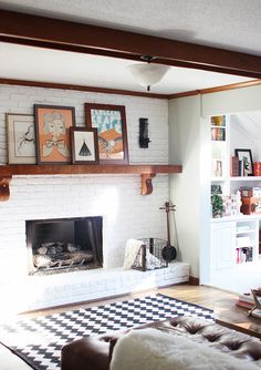 a living room with white brick fireplace and black and white checkerboard flooring