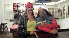 two people are posing for a photo in a barber shop