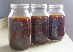 three jars filled with liquid sitting on top of a table