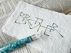 a piece of paper with the word brother written on it next to a paintbrush