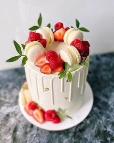 a white cake topped with fruit on top of a table