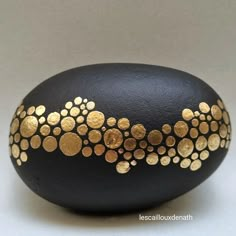 a black and gold painted rock sitting on top of a table