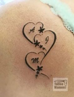 the back of a woman's stomach with a heart and flowers tattoo on it