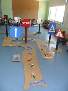 children's play area with various road signs and traffic lights on the floor in front of them