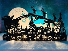 a christmas scene with santa sleigh and reindeers in the sky, surrounded by snow