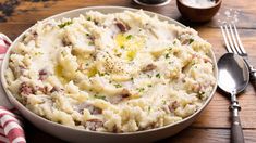 mashed potatoes with ham and gravy in a white bowl on a wooden table