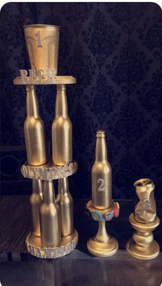 three golden beer bottles are stacked on top of each other and one has a cup in the middle