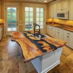 a kitchen with an island made out of wood in the middle of it and white cabinets