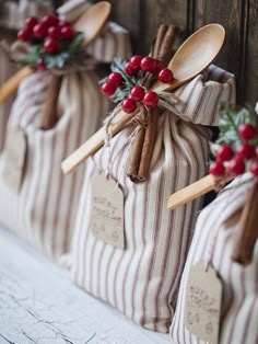 wooden spoons are wrapped in burlocks and tied with twine, holly berries and cinnamon sticks