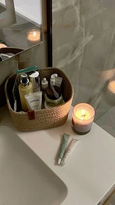 a bathroom sink with soap, lotion and candles on it