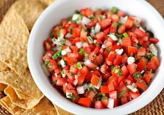 a white bowl filled with salsa and tortilla chips on top of a table