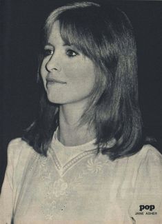 an old black and white photo of a woman with long hair, wearing a sweater