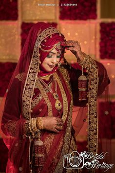 a woman in a red and gold bridal outfit poses for the camera with her hands on her head