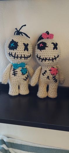 two crocheted stuffed animals sitting on top of a shelf