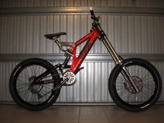 a red bike parked in front of a metal wall