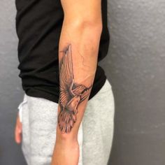 a person with a bird tattoo on their arm