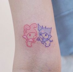 two small tattoos on the arm of someone's left arm, one with an animal and another with a cat