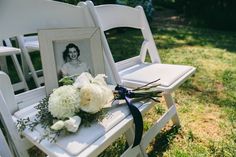 a white chair with flowers and a picture frame on it