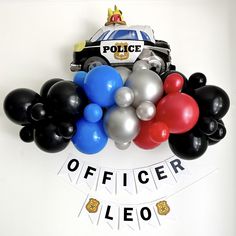 a police officer themed birthday party with balloons and streamers on the wall above it