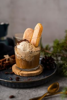 an ice cream sundae on a plate with cinnamon sticks