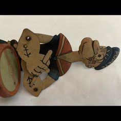 an old clock with wooden carvings on the front and back sides, sitting on a white surface