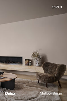 a living room with two chairs and a coffee table in front of a fire place