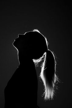 black and white photograph of a woman's profile with her hair blowing in the wind