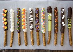 a row of decorated pretzels with eyes and candy sticks sticking out of them