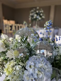 white and blue flowers are in front of disco ball centerpieces